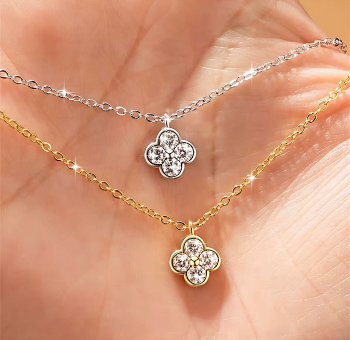 Klavertje vier moissanite ketting zilver en goud in hand