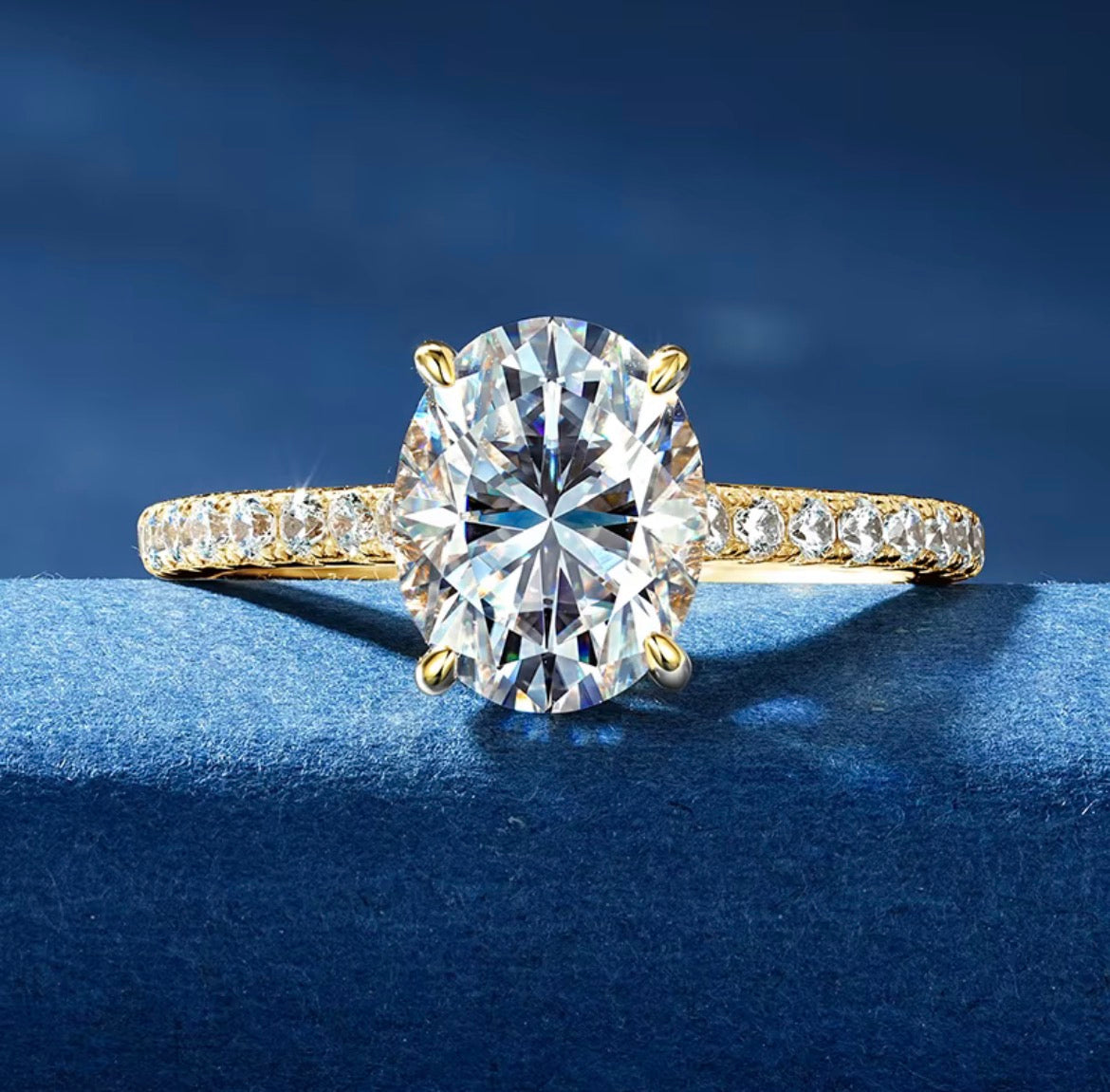 Ovale moissanite verlovingsring witgoud op blauwe stof